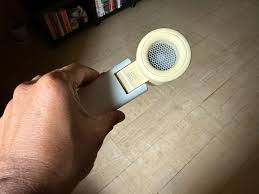 Person staying cool with a Delhi summer handheld fan in traffic